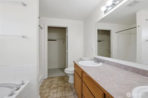 a bathroom with a granite countertop sink a toilet and shower