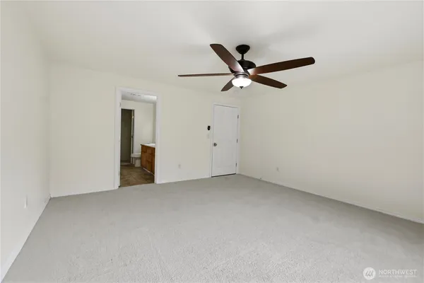 an empty room with closet and fan