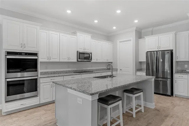 a kitchen with stainless steel appliances a stove a sink and a microwave