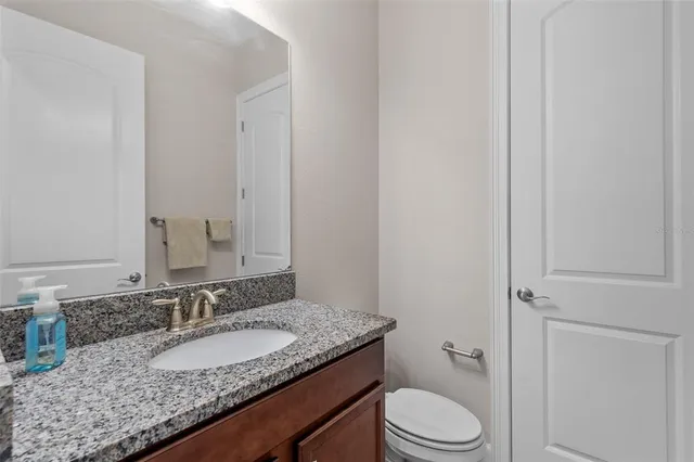 a bathroom with a granite countertop sink and a mirror