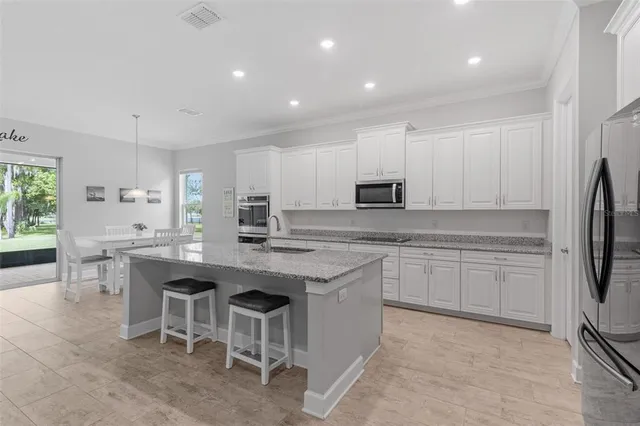 a kitchen with appliances a sink a counter top space and cabinets