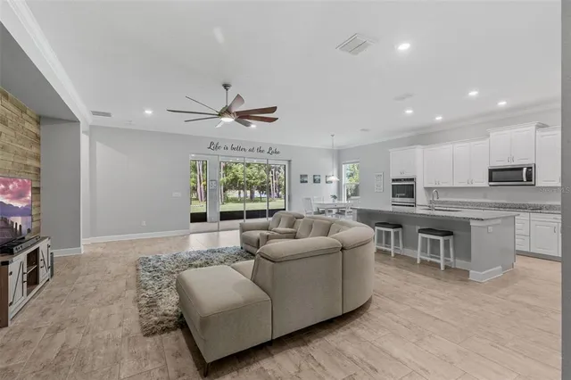 a living room with kitchen island furniture and a flat screen tv