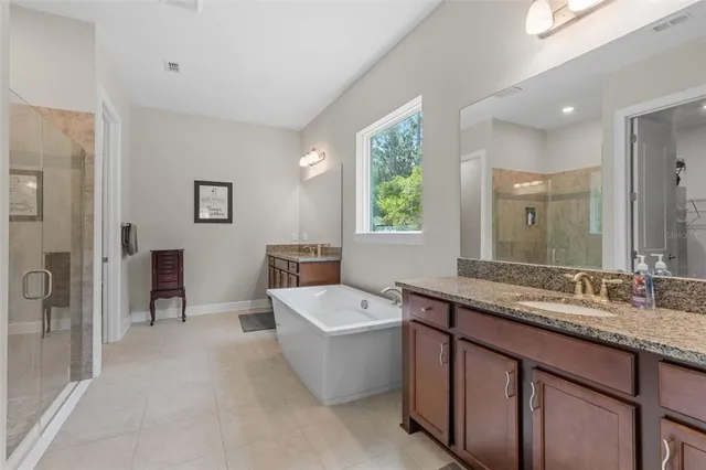 a bathroom with a granite countertop sink mirror and bathtub