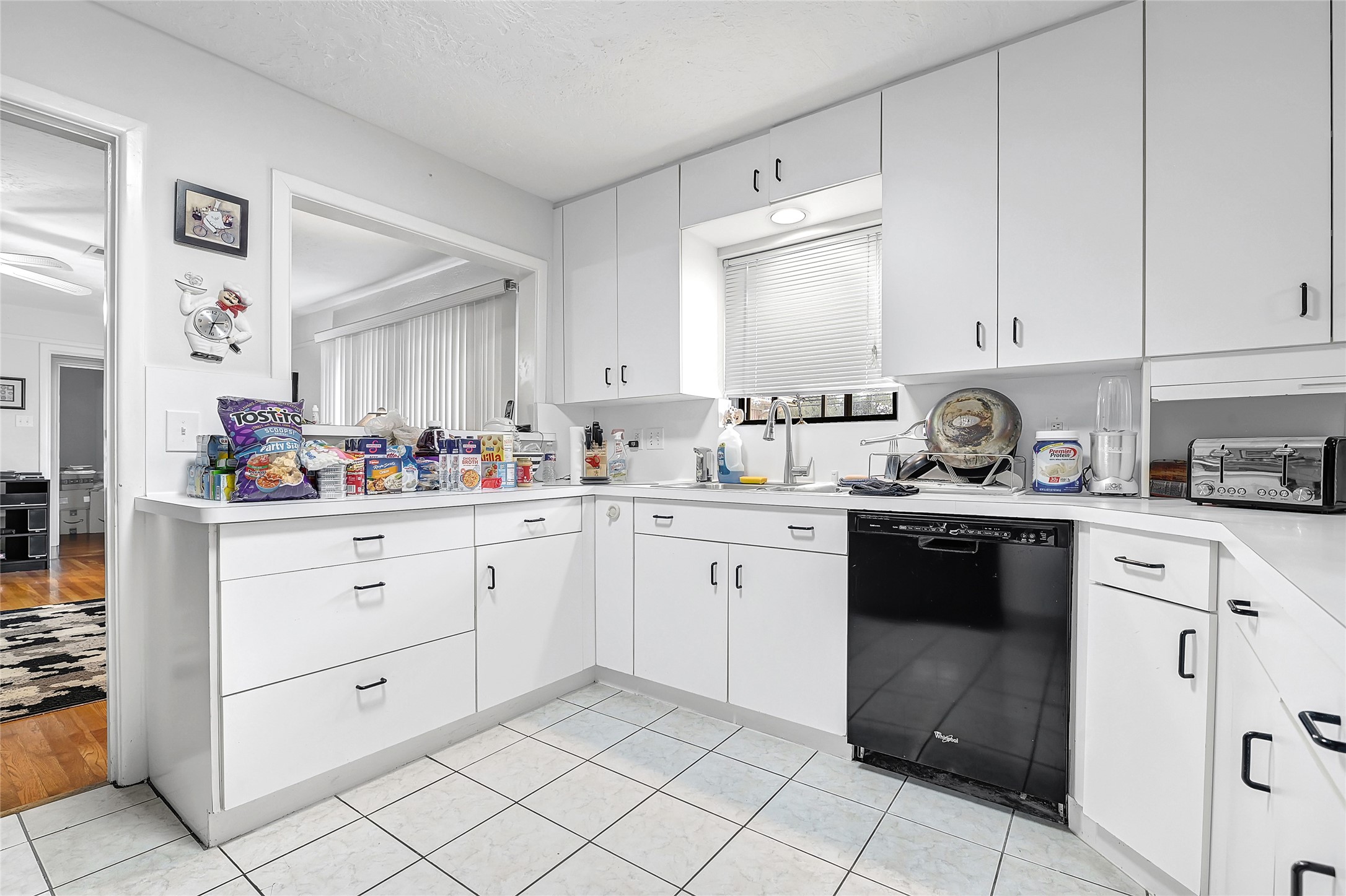 4831 Knickerbocker Street Houston, TX 77035 - Photo 25 of 50 White kitchen with modern cabinetry, stainless accents, and ample counter space.