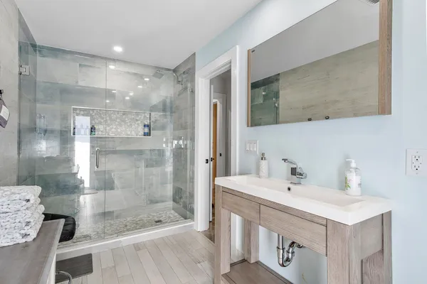 a bathroom with a double vanity sink mirror and shower
