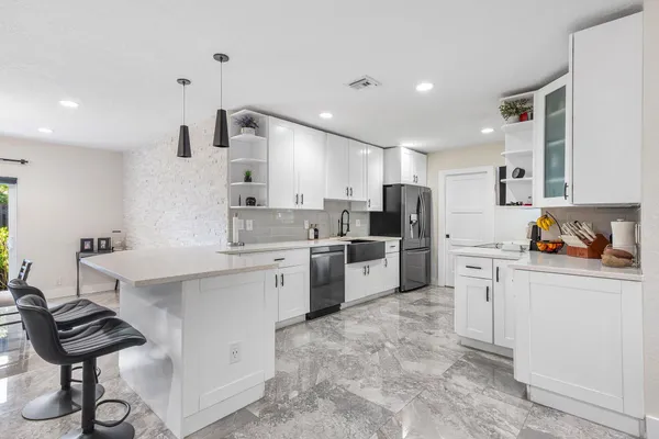 a kitchen with white cabinets and stainless steel appliances