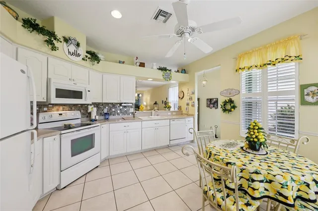 a kitchen with stainless steel appliances kitchen island granite countertop a table and chairs in it