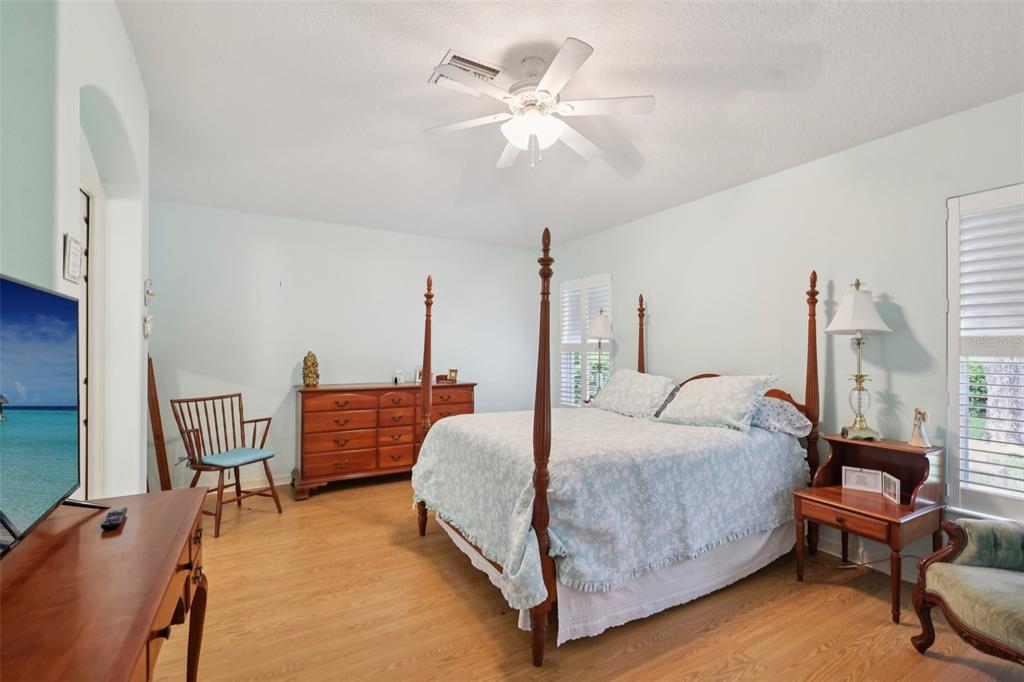 4954 Rainbow Trout Road Tavares, FL 32778 - Photo 20 of 37 a bedroom with a bed and a chandelier