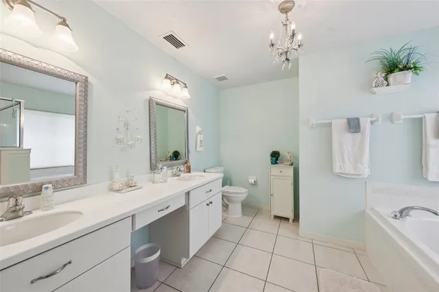 a spacious bathroom with a double vanity sink toilet and a mirror