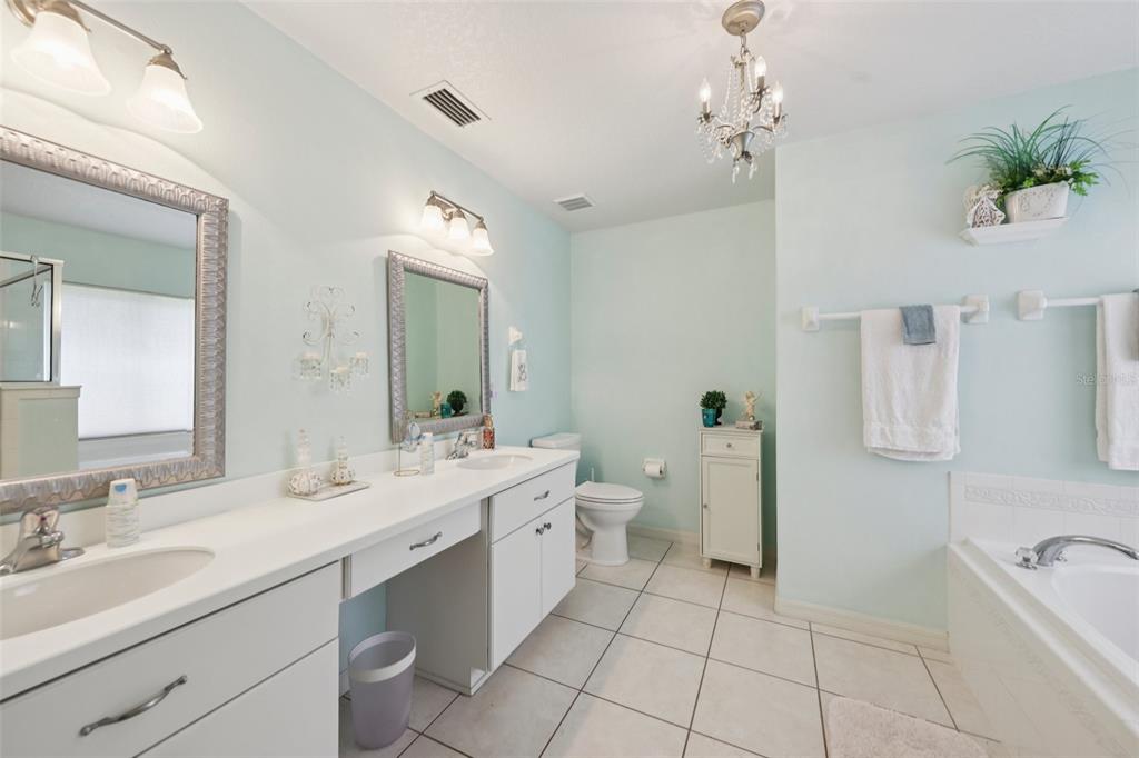 4954 Rainbow Trout Road Tavares, FL 32778 - Photo 23 of 37 a spacious bathroom with a double vanity sink toilet and a mirror