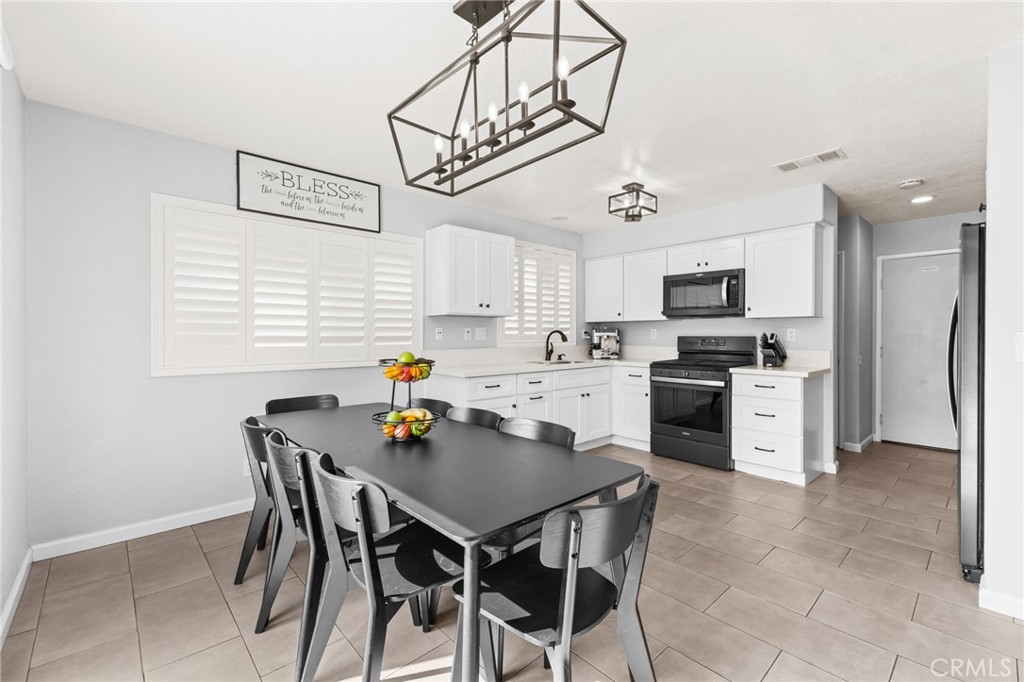 823 Pathfinder Way Corona, CA 92878 - Photo 17 of 59 a kitchen with stainless steel appliances a table chairs microwave and cabinets