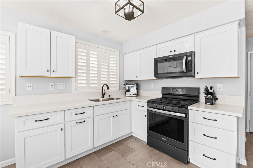 823 Pathfinder Way Corona, CA 92878 - Photo 19 of 59 a kitchen with white cabinets appliances and a sink