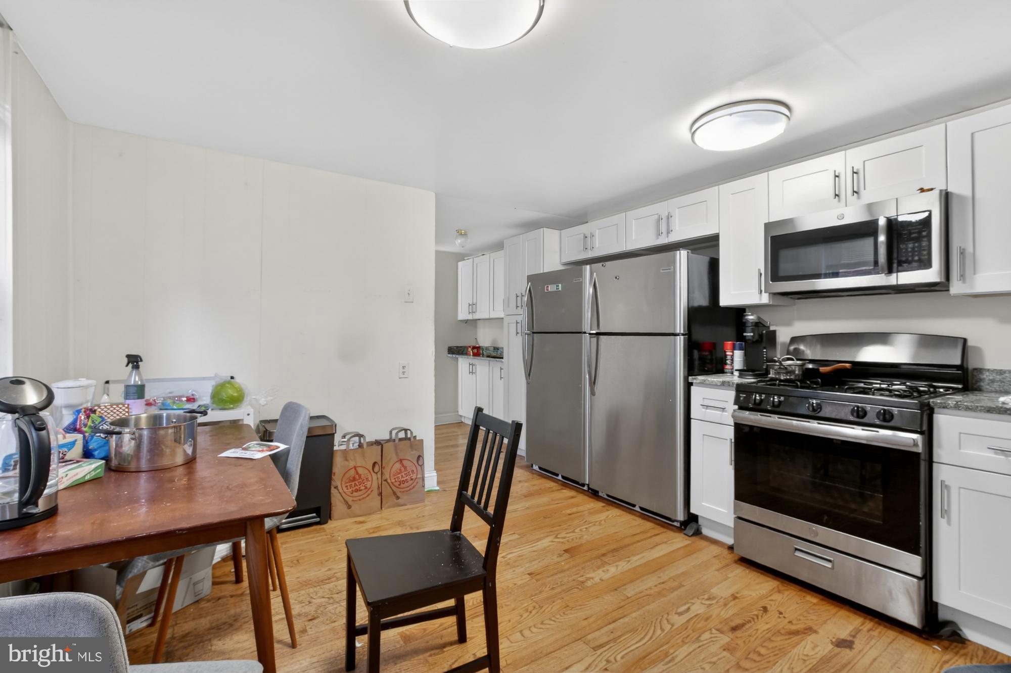 4058 Irving Street Philadelphia, PA 19104 - Photo 8 of 23 a kitchen with stainless steel appliances a stove a refrigerator a dining table and chairs