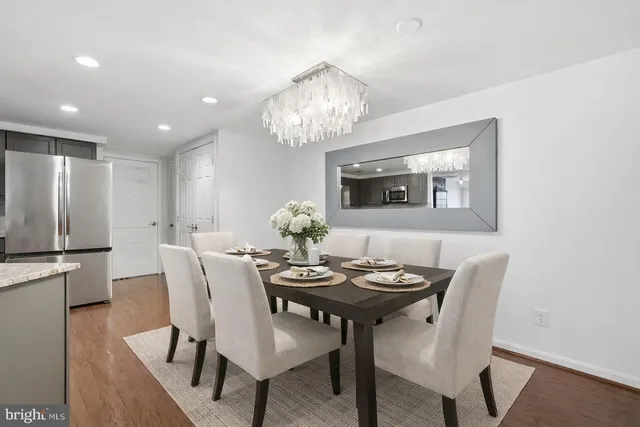 a view of a dining room with furniture a chandelier and wooden floor