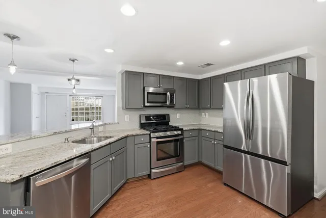 a kitchen with stainless steel appliances granite countertop a stove top oven a sink and dishwasher