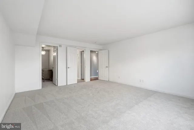 an empty room with an entryway and closet area
