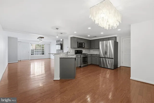a kitchen with stainless steel appliances granite countertop a refrigerator stove top oven and cabinets