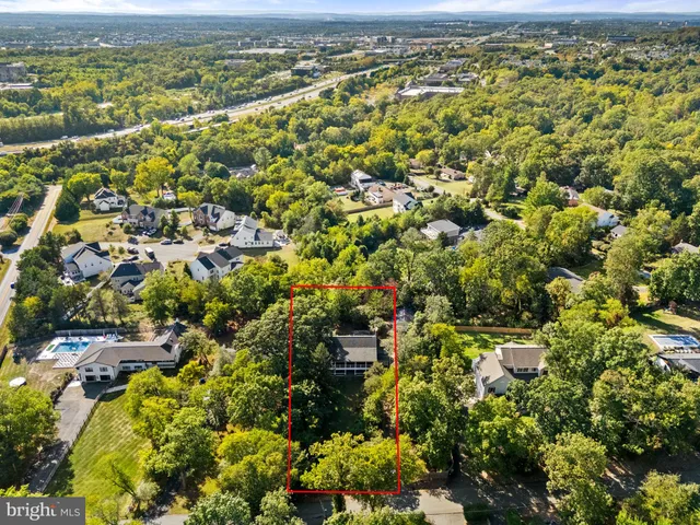 an aerial view of residential houses with outdoor space and trees