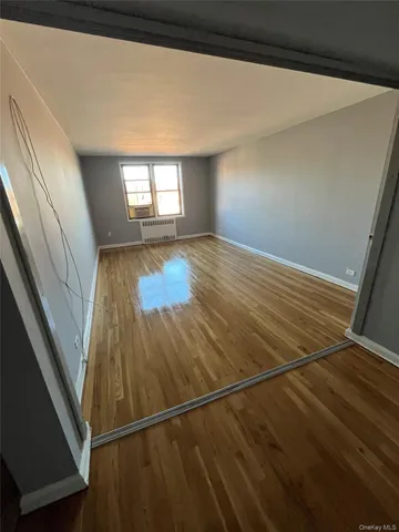a view of a room with wooden floor and window