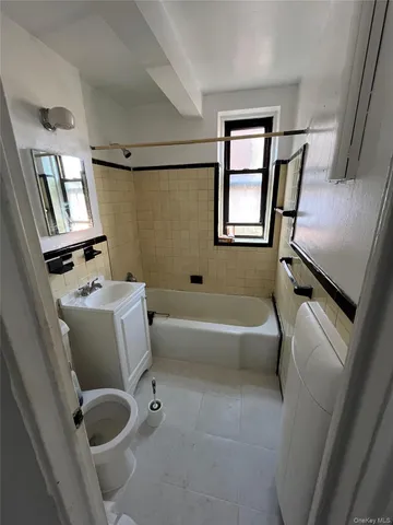 a bathroom with a tub sink and window