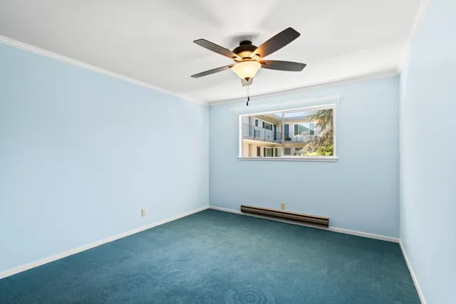 an empty room with a window and ceiling fan