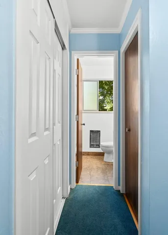 a view of a hallway with a white walls and a window