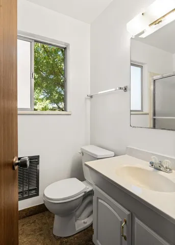 a bathroom with a toilet a sink and a mirror