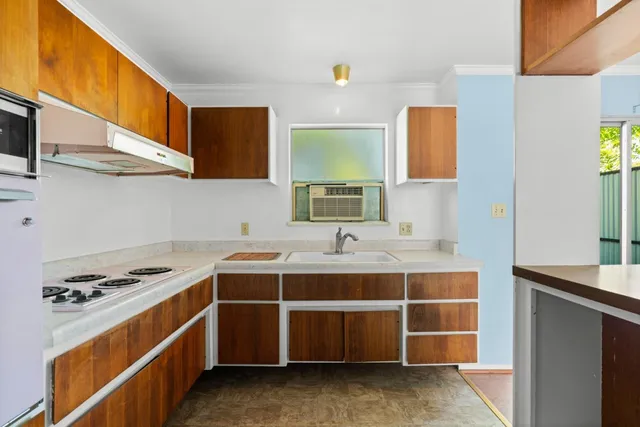 a view of cabinets a sink wooden floor and a window