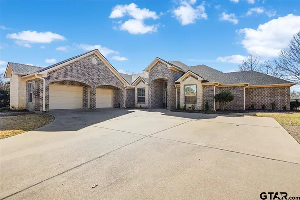 a front view of a house with a garden and trees