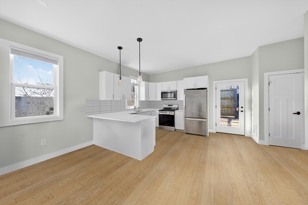 3 Walley Street Boston, MA 02128 - Photo 8 of 11 a kitchen with stainless steel appliances granite countertop a refrigerator a sink dishwasher a oven and white cabinets with wooden floor