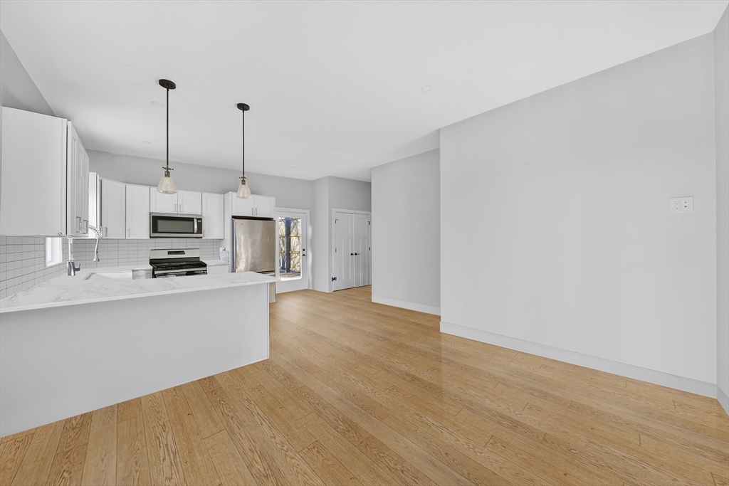 3 Walley Street Boston, MA 02128 - Photo 10 of 11 a kitchen with stainless steel appliances a refrigerator and a stove top oven