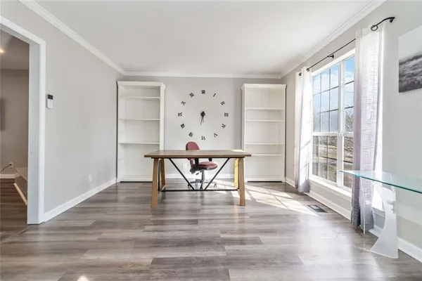 a view of an empty room with wooden floor fireplace and a window