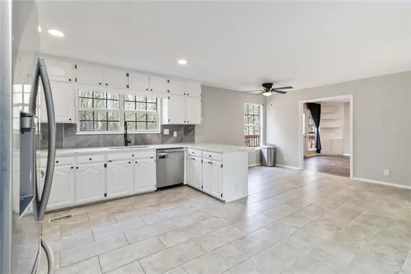 a kitchen with stainless steel appliances a refrigerator sink and white cabinets
