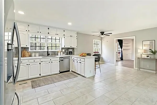 a large white kitchen with cabinets