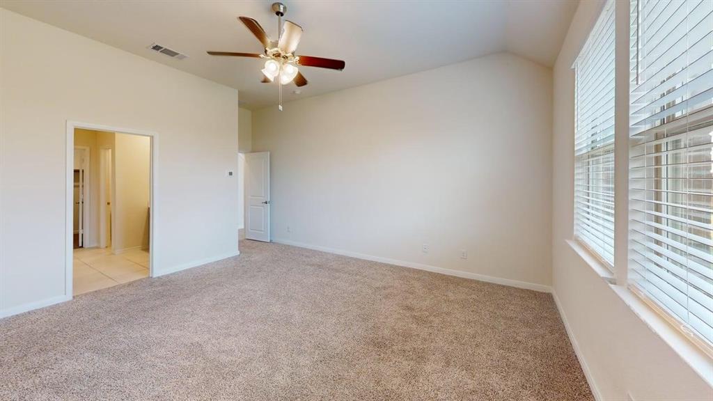 1306 Colonial Bluff Lane Princeton, TX 75407 - Photo 23 of 27 Carpeted interior space featuring a vaulted ceiling and a ceiling fan with integrated lighting
