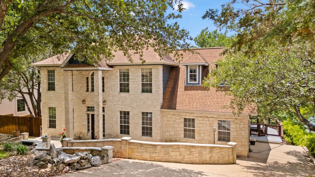 10800 Beach Road Leander, TX 78641 - Photo 2 of 39 An inviting stone-clad facade with a distinctive dormer welcomes you to this hillside residence.