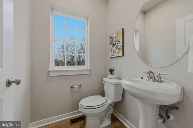 a bathroom with a toilet a sink and mirror