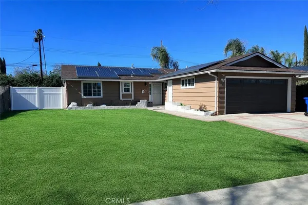 a front view of house with a garden