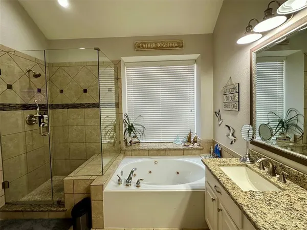 a bathroom with a granite countertop sink a bathtub and shower