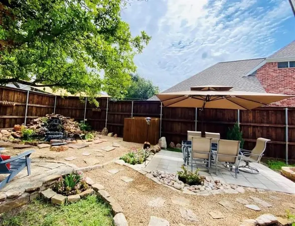 a view of backyard with seating space and wooden fence