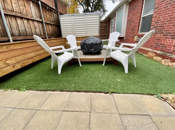 a backyard of a house with barbeque oven table and chairs