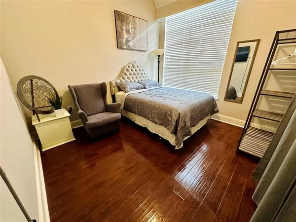 a bedroom with a bed wooden floor and window