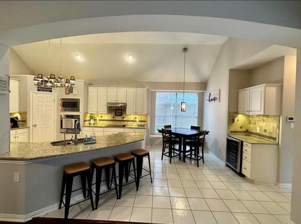 3607 Sable Ridge Drive Dallas, TX 75287 - Photo 10 of 30 a dining hall with stainless steel appliances kitchen island granite countertop a dining table chairs and granite counter tops