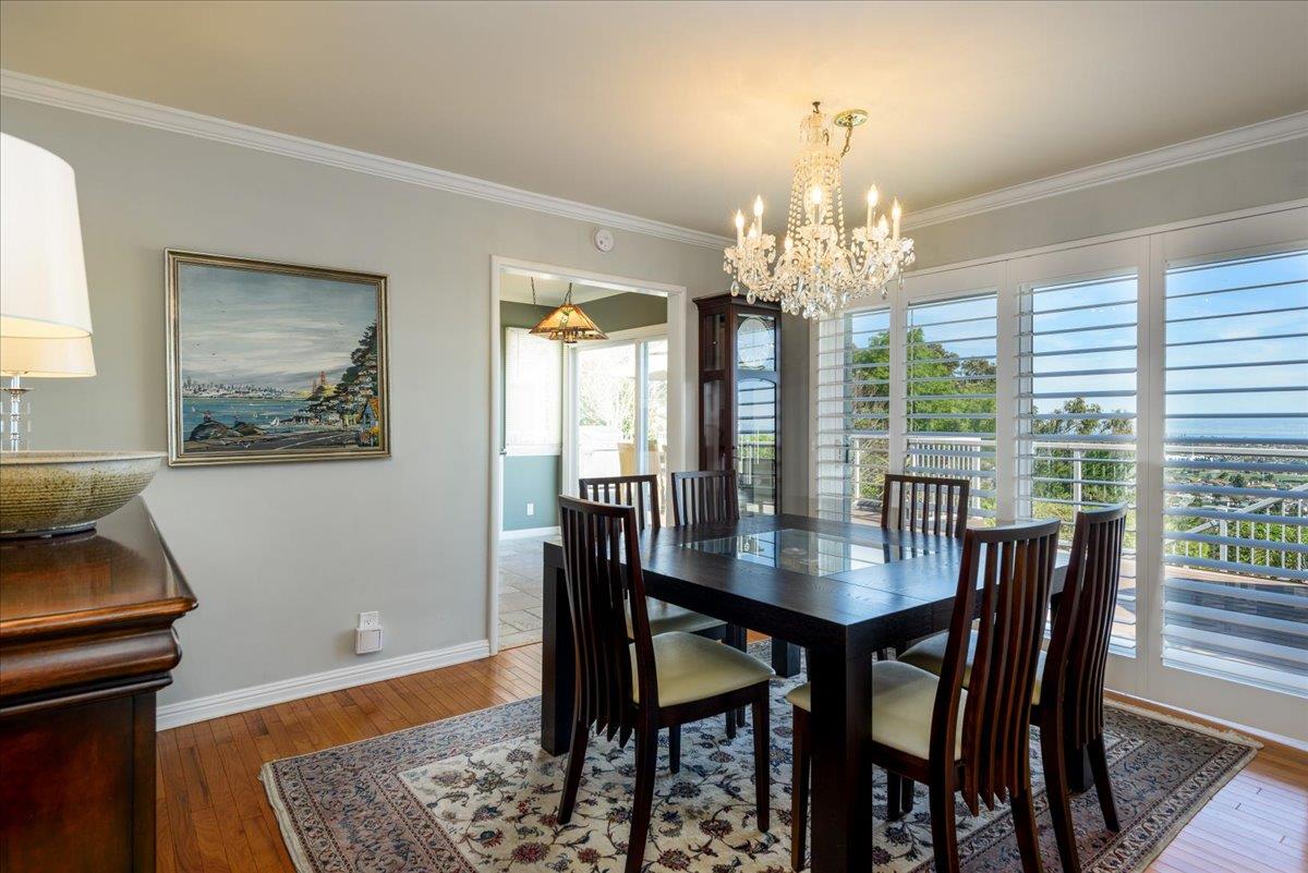 819 Holly Road Belmont, CA 94002 - Photo 23 of 75 a view of a dining room with furniture a chandelier and wooden floor