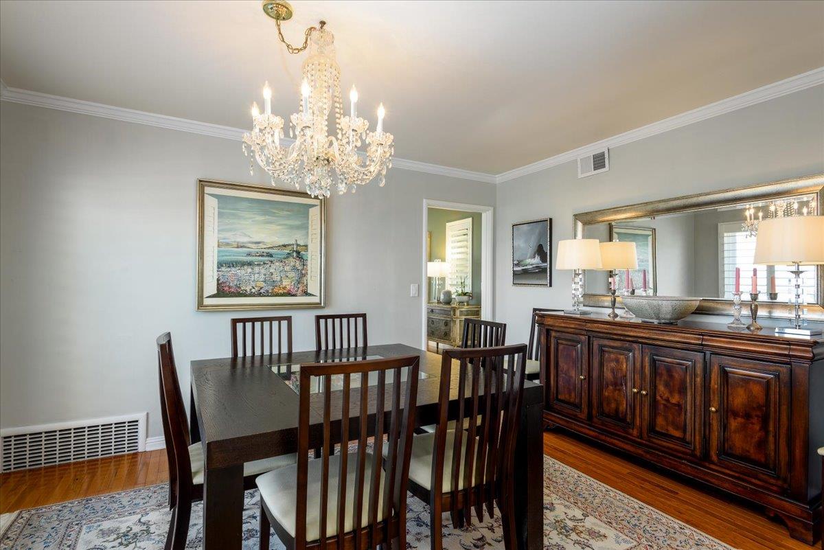 819 Holly Road Belmont, CA 94002 - Photo 24 of 75 a view of a dining room with furniture a chandelier and wooden floor