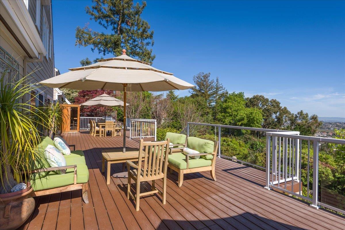 819 Holly Road Belmont, CA 94002 - Photo 40 of 75 a patio with wooden floor a yard a table and chairs