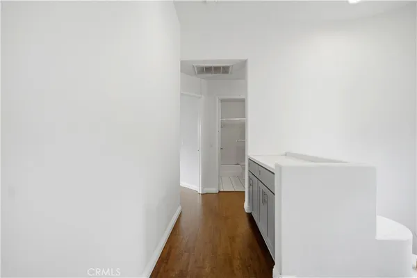 a view of an empty room with wooden floor