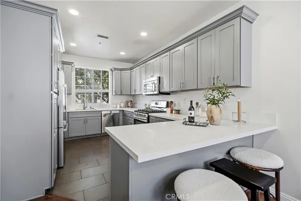 a kitchen with appliances a sink and cabinets