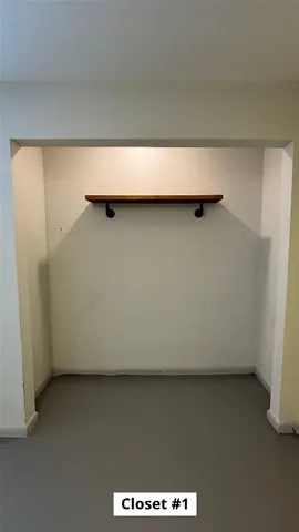 a room with water heater and wooden cabinets