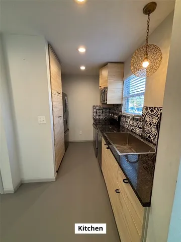 a kitchen with stainless steel appliances granite countertop a sink a stove and a refrigerator